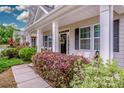Inviting front porch with seating and colorful landscaping offering curb appeal at 10707 Charmont Pl, Huntersville, NC 28078