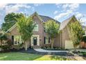 Charming brick two-story home features mature trees, lush landscaping, and a welcoming entrance at 12004 Willingdon Rd, Huntersville, NC 28078