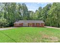 Charming brick ranch home with a lush green lawn and mature trees surrounding the property at 182 Freedom Mill Rd, Gastonia, NC 28052
