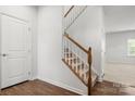 Staircase with carpeted steps, white risers, and wood handrail at 1933 Tin Roof Ln, Monroe, NC 28112