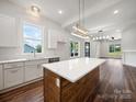 Spacious kitchen featuring white cabinetry, quartz countertops, stainless steel appliances, and an island at 217 S Green St, Wadesboro, NC 28170