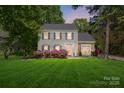 Charming two-story home featuring gray siding, black shutters, and a well-manicured lawn under an enchanting evening sky at 2224 Clonmel Pl, Charlotte, NC 28262