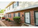 Charming brick townhouse features black shutters, neat landscaping, and inviting entryway at 2332 Kenmore Ave, Charlotte, NC 28204