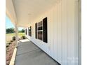 Inviting covered porch with white columns and black shutters along the side of the house at 296 Tram Rd, Lancaster, SC 29720