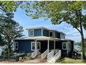 Inviting two-story home with a metal roof, landscaped yard, and water views at 31009 Executive Pt, Tega Cay, SC 29708