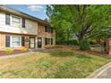 Inviting townhome exterior featuring brick accents, lush lawn, and mature shade trees at 3726 Park Rd, Charlotte, NC 28209