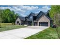 Gorgeous modern home with mixed brick and board siding, a long driveway, and a spacious three-car garage at 4377 Kiser Island Rd, Terrell, NC 28682