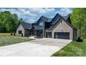 Beautiful modern home with brick and board siding, a concrete driveway, and manicured lawn at 4377 Kiser Island Rd, Terrell, NC 28682