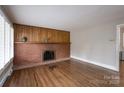 Spacious living room featuring hardwood floors and a classic brick fireplace at 4920 Raymond Pl, Charlotte, NC 28205
