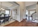 Spacious entryway featuring hardwood floors, wainscoting, and views into the dining and living areas at 525 Chase Prairie Ln, Waxhaw, NC 28173