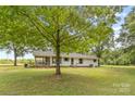 A cozy one-story home with a screened-in porch and backyard lawn surrounded by mature trees at 5317 Friendly Baptist Ch Rd, Indian Trail, NC 28079