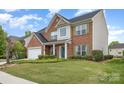 Attractive two-story brick home with a pristine lawn, two-car garage and manicured hedges at 5803 Lindley Crescent Dr, Indian Trail, NC 28079