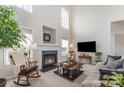 Bright living room with soaring ceilings, a cozy fireplace, and neutral decor at 5803 Lindley Crescent Dr, Indian Trail, NC 28079