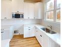 Bright kitchen features white cabinets, stainless steel appliances, light countertops, and a window at 606 Banter Ln # 30, Cramerton, NC 28032