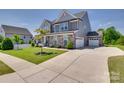 A long driveway leads to this gray two-story home with stone accents and an attached garage at 6113 Russo Ct, Lancaster, SC 29720
