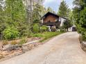 Two-story home with driveway, surrounded by lush greenery and landscaped yard at 85 Riley Dr, Taylorsville, NC 28681