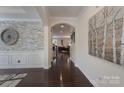 Elegant foyer with hardwood floors, stone accent wall, decorative art, and an arched entryway leading to other rooms at 866 Tyne Dr, Fort Mill, SC 29715