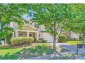 Charming home with mature trees, a two-car garage, lush landscaping, and a welcoming front porch at 8919 Oransay Way, Charlotte, NC 28278