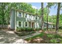 Side view of a sage green two-story home with a well-maintained yard and mature trees providing shade at 8936 Rittenhouse Cir, Charlotte, NC 28270