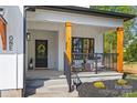 Inviting front porch with black metal railing, wood columns, and seating area at 1 Linestowe Dr, Belmont, NC 28012