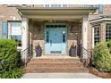 Charming front entrance with a blue door, brick steps, and manicured landscaping at 101 Stonehurst Ln, Waxhaw, NC 28173