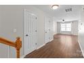 Inviting hallway featuring hardwood floors, white trim, and multiple doors at 11011 Alderbrook Ln, Charlotte, NC 28270