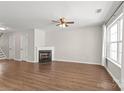 Spacious living room showcasing a fireplace, fan, and hardwood floors at 11011 Alderbrook Ln, Charlotte, NC 28270