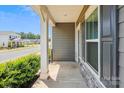 Inviting covered front porch with stone accents, white columns, and a view of the neighborhood street at 13210 Kenworth Rd, Charlotte, NC 28278