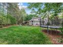 A spacious backyard with lush green grass and mature trees, featuring a trampoline at 1509 Kirkbridge Ct, Matthews, NC 28105