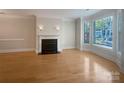 Bright living room featuring hardwood floors, a decorative fireplace, and abundant natural light from the large windows at 151 Harper Lee St, Davidson, NC 28036