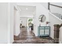 Bright foyer featuring wood floors, staircase, and a decorative cabinet at 15108 Autumn Sage Dr, Charlotte, NC 28278