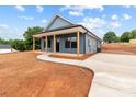 Single-story home showcasing a covered porch, modern blue siding, and a well-manicured lawn at 15700 Stokes Ferry Rd, Richfield, NC 28137
