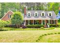 Charming brick home with a manicured front lawn, mature landscaping, and a cozy front porch at 2062 High Pines Rd, Rock Hill, SC 29732