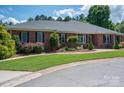 Charming brick home with a well-maintained lawn and mature landscaping at 216 Commodore Ct, Belmont, NC 28012
