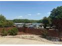 Picturesque view of the lake and the marina from behind a decorative brick wall and landscaping at 216 Commodore Ct, Belmont, NC 28012