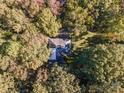 Aerial view of home nestled among lush trees in a private, wooded setting at 2643 Rolling Hills Dr, Monroe, NC 28110