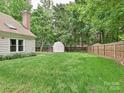 Backyard features a lush lawn, fenced perimeter, and storage shed at 3612 Woodnotch Ct, Charlotte, NC 28269