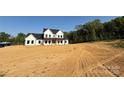 Inviting two-story white home with a covered front porch on a spacious lot at 4034 Daugherty Rd, China Grove, NC 28023