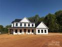 Newly constructed two-story home with black trim, covered porch and wooded backdrop at 4040 Daugherty Rd, China Grove, NC 28023
