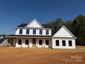 Newly constructed two-story home with black trim, covered porch and wooded backdrop at 4040 Daugherty Rd, China Grove, NC 28023