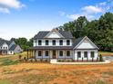 Charming two-story farmhouse with a welcoming front porch and manicured landscaping at 4040 Daugherty Rd, China Grove, NC 28023