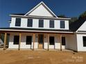 Inviting two-story home with a covered front porch, natural wood posts and front door at 4040 Daugherty Rd, China Grove, NC 28023