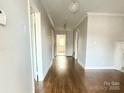 Bright hallway featuring hardwood floors, neutral walls, and elegant lighting, leading to various rooms at 406 S Catawba St, Lancaster, SC 29720