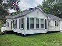 A lovely home exterior featuring crisp white siding, black shutters, and a cozy front porch at 507 Chrysler St, Kannapolis, NC 28083