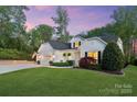 Side view of a beautifully landscaped home with a well-maintained lawn and three-car garage at 5490 Sapwood Ct, Denver, NC 28037