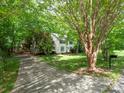 Exterior view showcasing a traditional-style home with an extended driveway and lush landscaping at 6100 Hunter Ln, Weddington, NC 28104