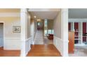 Elegant foyer with hardwood floors, a staircase, and decorative columns offering a view into the living spaces at 6100 Hunter Ln, Weddington, NC 28104