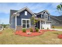 Beautiful home featuring blue siding, white trim, and a well-maintained lawn at 705 Hinterland Ln, Matthews, NC 28104
