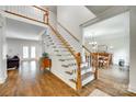 Bright foyer with staircase, hardwood floors, and view into dining area at 7122 Forest Ridge Rd, Matthews, NC 28104