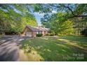 Brick home with a detached carport features a well-kept lawn and ample parking space at 8222 Henry Harris Rd, Fort Mill, SC 29707